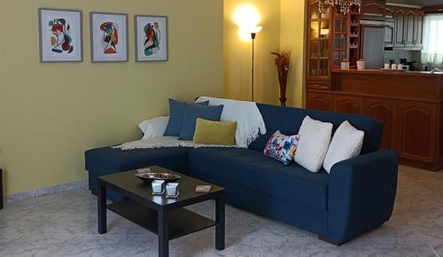 a blue couch in a living room with a table at Kelly's penthouse in Nafpaktos