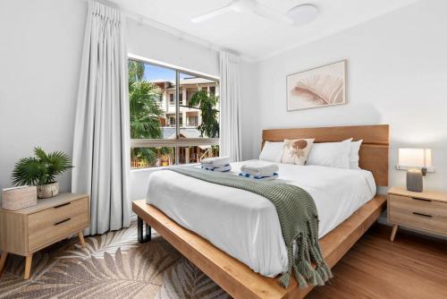 ein weißes Schlafzimmer mit einem großen Bett und einem Fenster in der Unterkunft The Nest Cairns - 4 pools BBQ & Resort in Cairns North