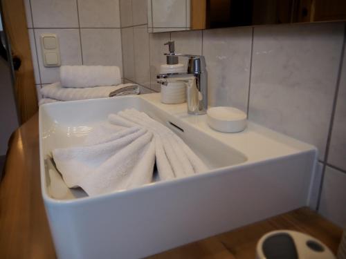 a white sink with towels on it in a bathroom at ERLEBNISBAUERNHOF Steinerhof in Kärnten in Liebenfels