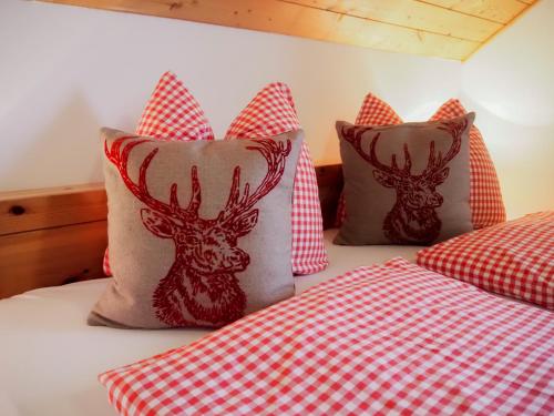 a bedroom with two beds with red and white pillows at ERLEBNISBAUERNHOF Steinerhof in Kärnten in Liebenfels