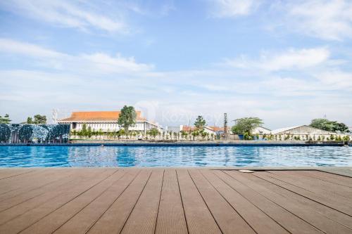 a wooden pier next to a swimming pool at Kiara by Kozystay - Paskal in Bandung