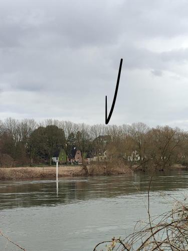 a black arrow is flying over a river at Apartment 58- Ruhr Nah in Essen