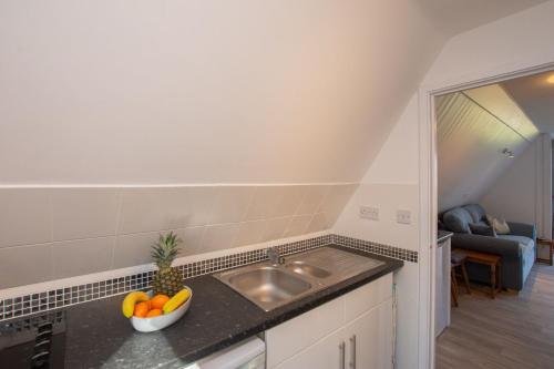 een keuken met een wastafel en een fruitschaal op een aanrecht bij Chalet Sixtysix in Deal
