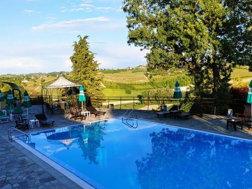 a large blue swimming pool with a view of a field at Locanda del Boscogrande in Montegrosso dʼAsti