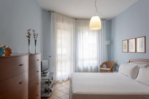 a bedroom with a white bed and a television at Appartamento Betti in Rapallo