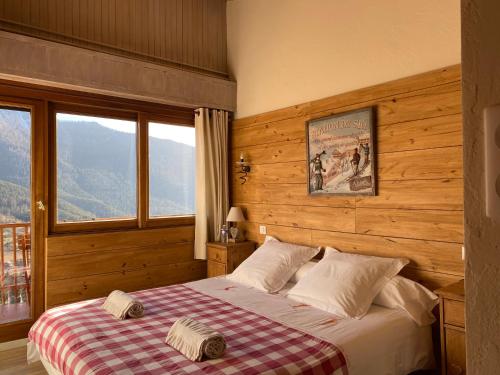 a bedroom with a bed with a checkered blanket at Chambres d'hôtes Le Grand Chalet in Valdeblore