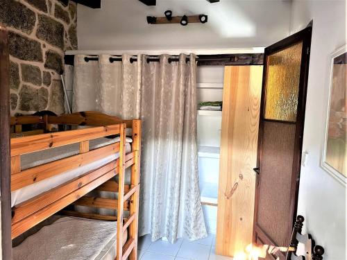 ein Schlafzimmer mit einem Etagenbett und einem Fenster in der Unterkunft Charmante maison de campagne avec piscine in Sartène