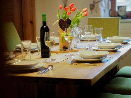 a table with plates and glasses and a bottle of wine at ERLEBNISBAUERNHOF Steinerhof in Kärnten in Liebenfels