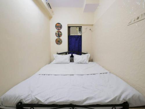 - une chambre avec un grand lit blanc et une porte bleue dans l'établissement Solace - 1 BHK - Walk away from Carter road, à Mumbai