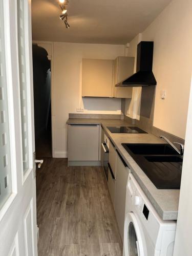 a kitchen with a sink and a dishwasher at Southsea HomeStays - Three Bedroom Home, Sleeps 8 - with Garden & Hot Tub in Portsmouth