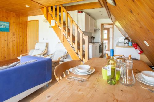een eetkamer met een houten tafel en een blauwe bank bij Chalet Seventyfour in Deal