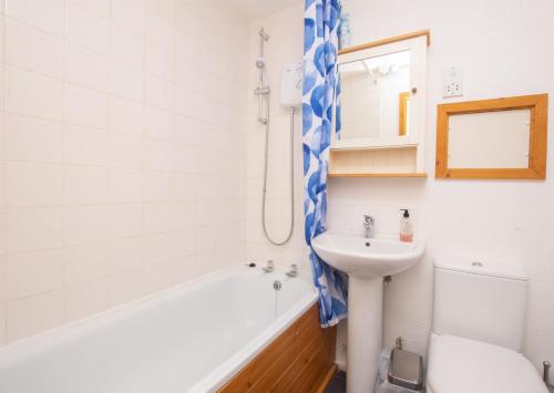 een badkamer met een wastafel, een bad en een toilet bij Chalet Seventyfour in Deal
