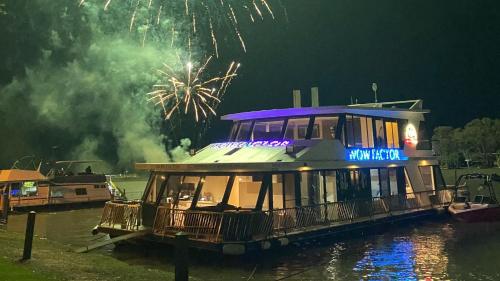 un bateau dans l'eau avec un feu d'artifice dans l'établissement Wow Houseboats Pty Ltd, à White Sands