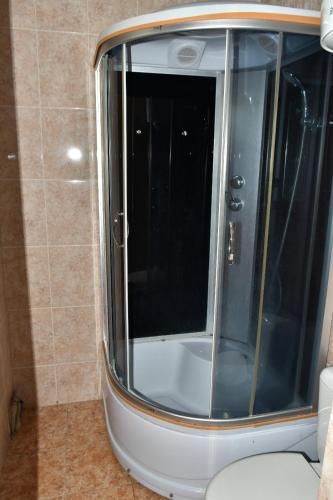 uma cabina de duche em vidro numa casa de banho com WC em пансионат Нептун em Korumdy