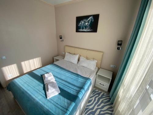 Dormitorio pequeño con cama con manta azul en Astana Arena Apartment, en Astana