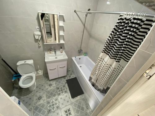 阿斯塔納的住宿－Astana Arena Apartment，浴室配有盥洗盆、卫生间和浴缸。