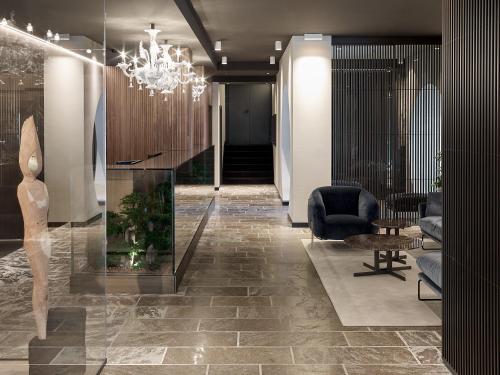 a lobby with a chair and a chandelier at Hotel San Giacomo Spa&Gourmet in Brentonico