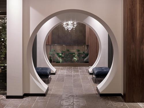 a hallway with an archway with chairs in a building at Hotel San Giacomo Spa&Gourmet in Brentonico