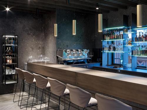a bar with a row of chairs in a room at Hotel San Giacomo Spa&Gourmet in Brentonico
