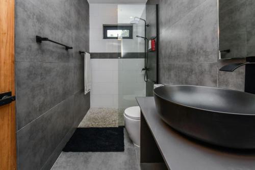 uma casa de banho com um lavatório preto e um WC. em 5 bedroom Villa Nune soul beach festival special em Paradera