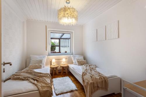 a bedroom with two beds and a chandelier at Scandinavian in Schloß Holte-Stukenbrock