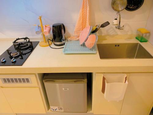 a kitchen counter top with a sink and a sink at Apartemen Sky House BSD by Benchmark in Tangerang