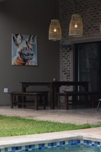 a patio with benches next to a swimming pool at Hyena Den - Marloth Park in Marloth Park