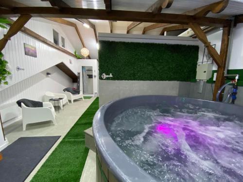 una grande vasca da bagno in una stanza con schermo di proiezione di Complex Turistic Dávid a Boghiş