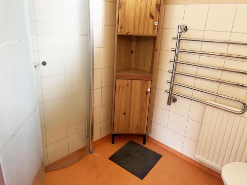 y baño con armario de madera y ducha. en Pleasant villa in Farjestaden located just a few minutes from the sea, en Färjestaden