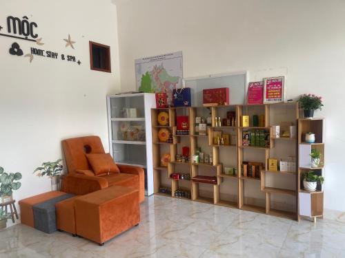 a room with a chair and a book shelf at Moc homestay- Near Bai Dai Beach in Cam Lâm