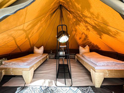 a room with two beds in a tent at raus und gut Glamping am Gräbendorfer See in Drebkau