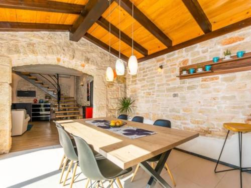 a dining room with a wooden table and chairs at Villa Macan by IstriaLux in Svetvinčenat