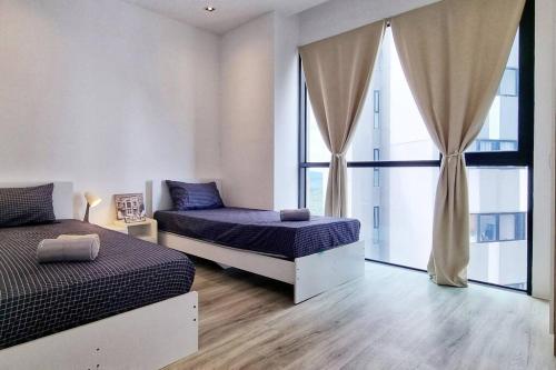 een slaapkamer met 2 bedden en een raam bij Tropicana Golf view 7pax -1 Utama - Ikea -The Curve in Petaling Jaya