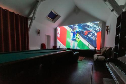 a room with a pool table and a large screen at Les Ifs en Sologne avec piscine: Château & Beauval in Millançay