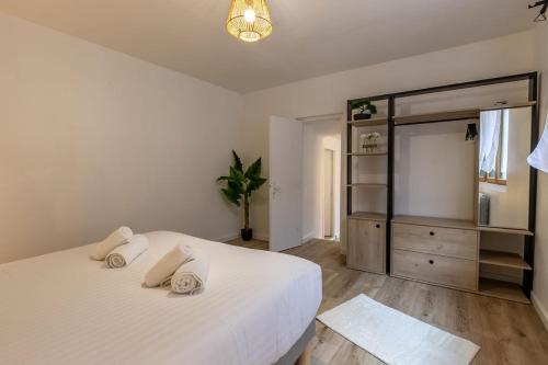 a bedroom with a large white bed and a dresser at L'Appart des Platanes in Romorantin