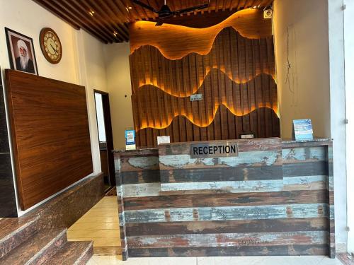 un restaurante con una pared de madera con un cartel. en The Maduka, en Chandīgarh