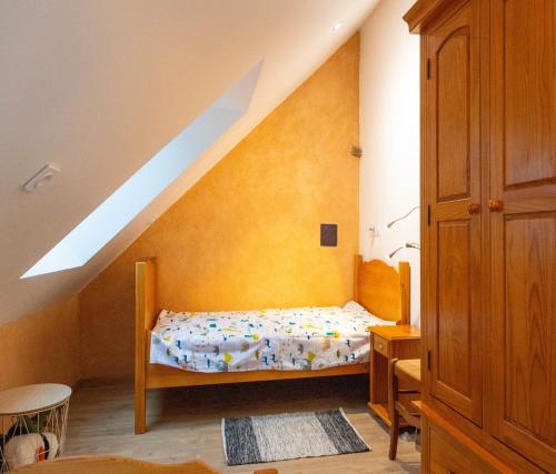 una piccola camera da letto con un letto in mansarda di La Thébaïde a Missillac