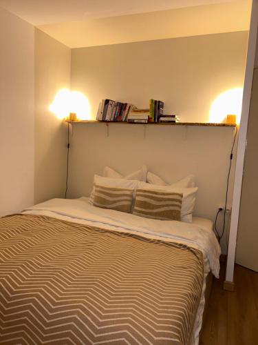 a bedroom with a bed with two lights above it at Appartement Bezons - La Défense in Bezons