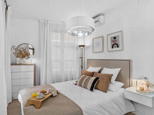 a white bedroom with a bed with a tray on it at Elegant and Central Location in Granada