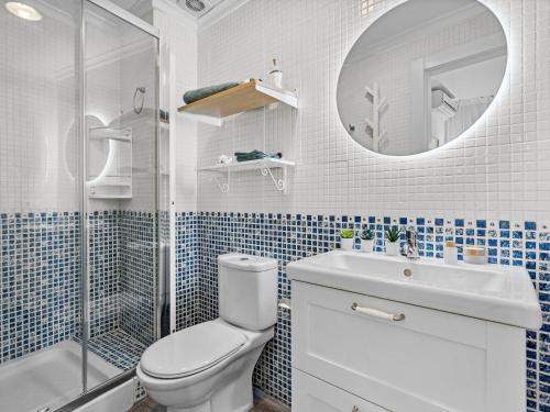 ein Badezimmer mit einem WC, einem Waschbecken und einem Spiegel in der Unterkunft Elegant and Central Location in Granada
