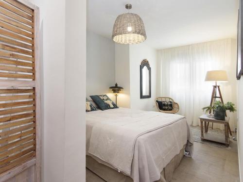 a bedroom with a bed and a pendant light at Chezmoihomes Apartment Cathedral 2 dormitorios in Granada