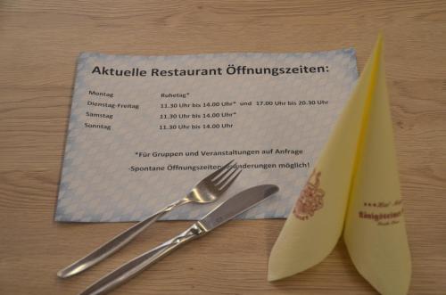 a permit with a fork and knife on a table at Hotel Königsteiner Hof in Königstein in der Oberpfalz