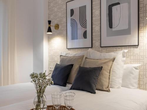 um quarto com uma cama branca com almofadas em Central Stylish and Elegant 1 & 2 BR apartments I em Granada