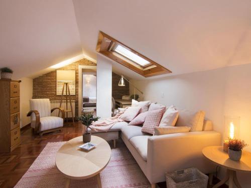 Chezmoihomes Alhambra Penthouse في غرناطة: غرفة معيشة مع أريكة وطاولة