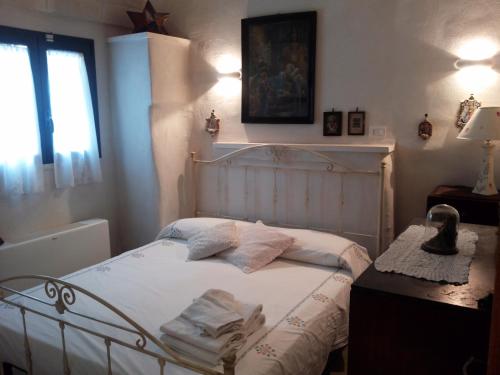 una camera da letto con un letto bianco e cuscini sopra di Trullo Messapico a Ceglie Messapica