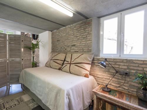 グラナダにあるChezmoihomes Loft Cathedralのレンガの壁、ベッド付きのベッドルーム1室