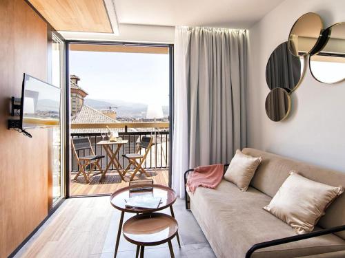 a living room with a couch and a balcony at Luxury Alhambra Penthouse Collection in Granada