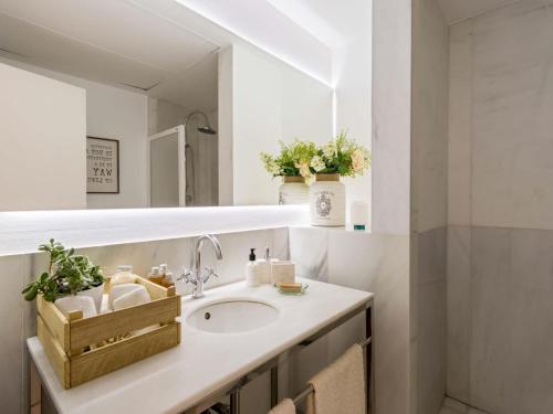 een badkamer met een wastafel en een spiegel bij Trinidad Deluxe 1 in Granada