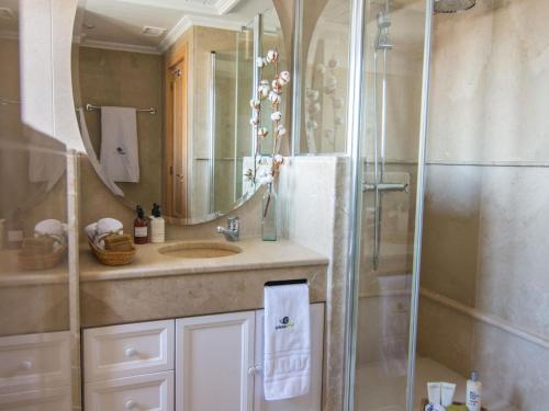 a bathroom with a sink and a shower with a mirror at Chezmoihomes Luxury Penthouse in Granada