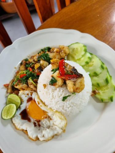 a plate of food with rice and eggs and vegetables at Sawasdee Sichang Resort in Ban Tha Thewawong